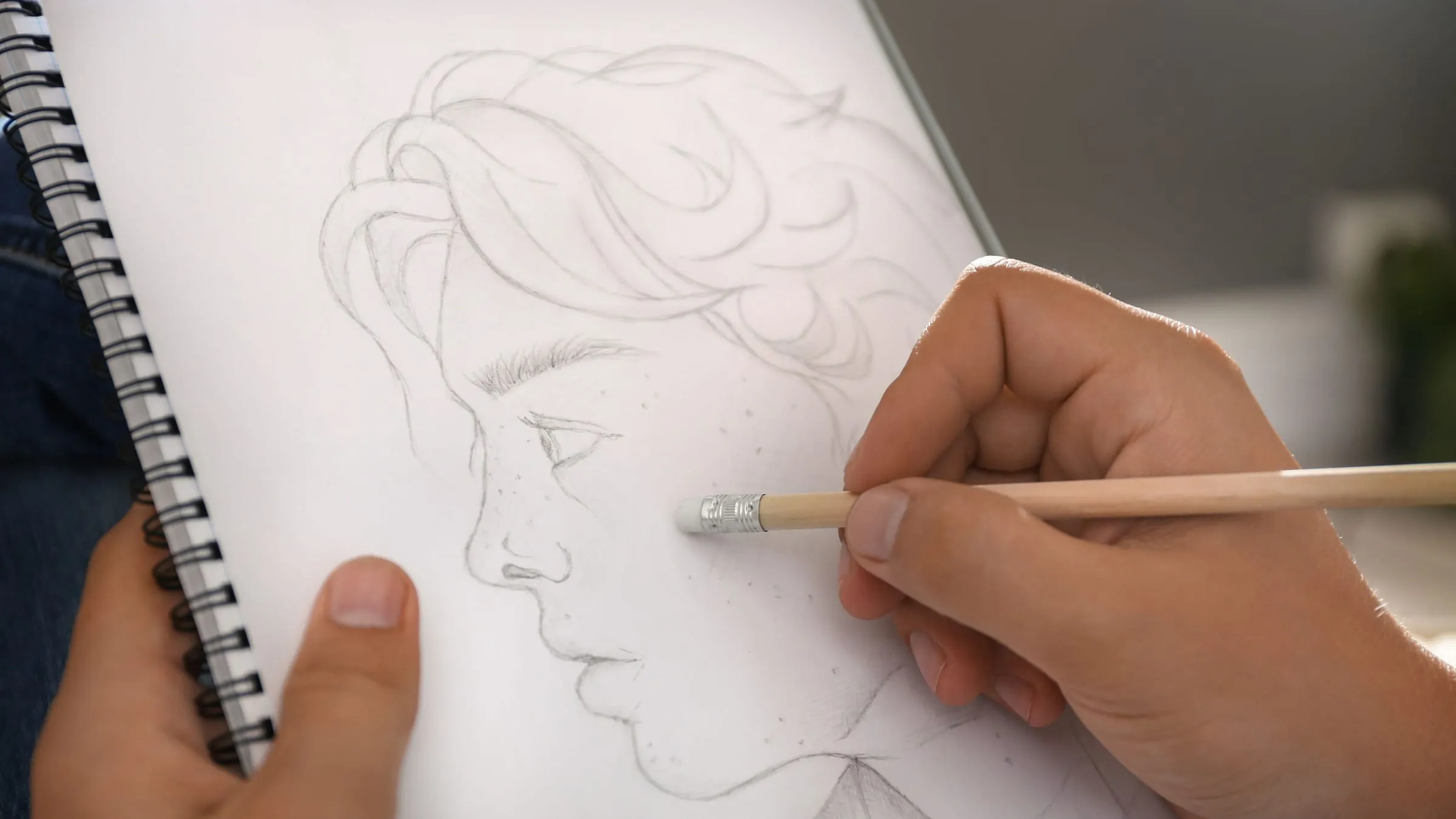 A pencil sketch of a face in a spiral sketchbook, the picture a soulmate sketch free offer promises
