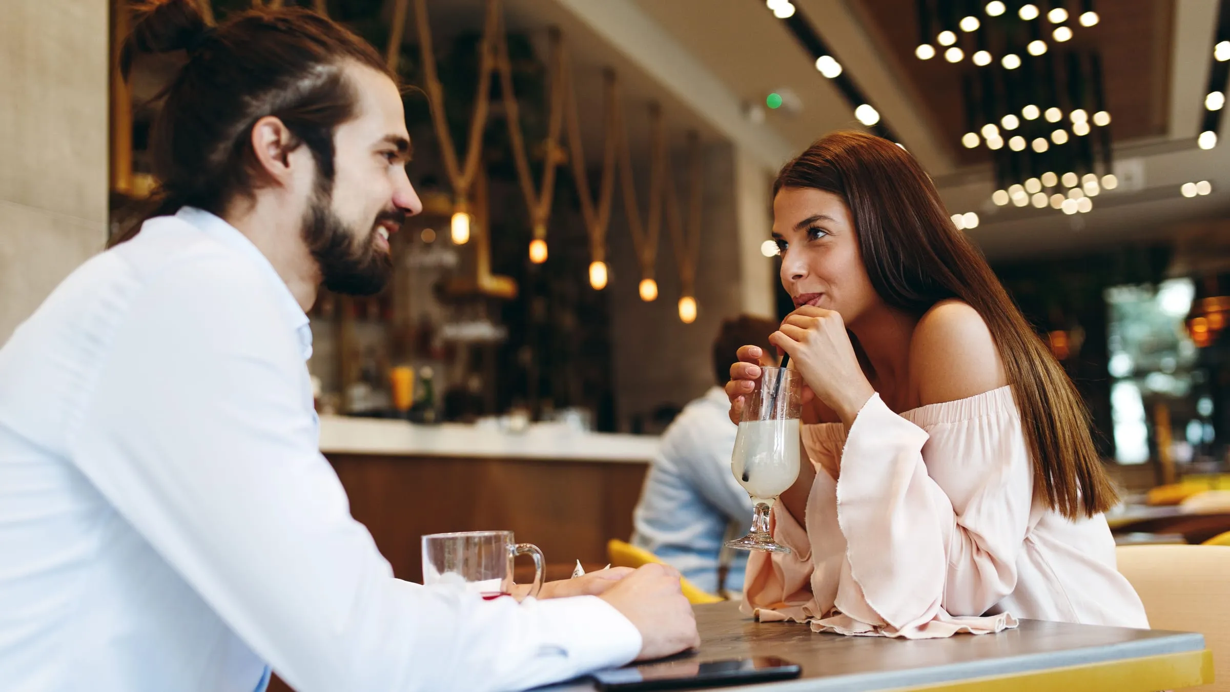 How to find your soulmate: a man and a woman talking across a cafe table, leaning toward each other