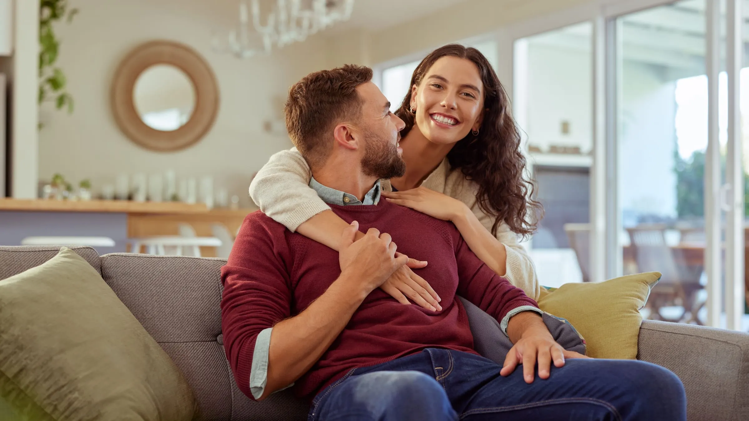 How to know if someone is your soulmate: a couple laughing on a sofa, at ease with each other